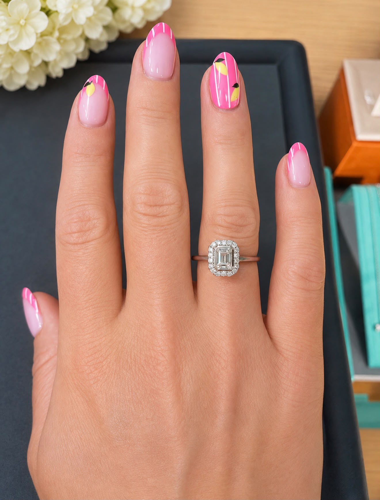 Emerald cut diamond halo engagement ring worn on a hand